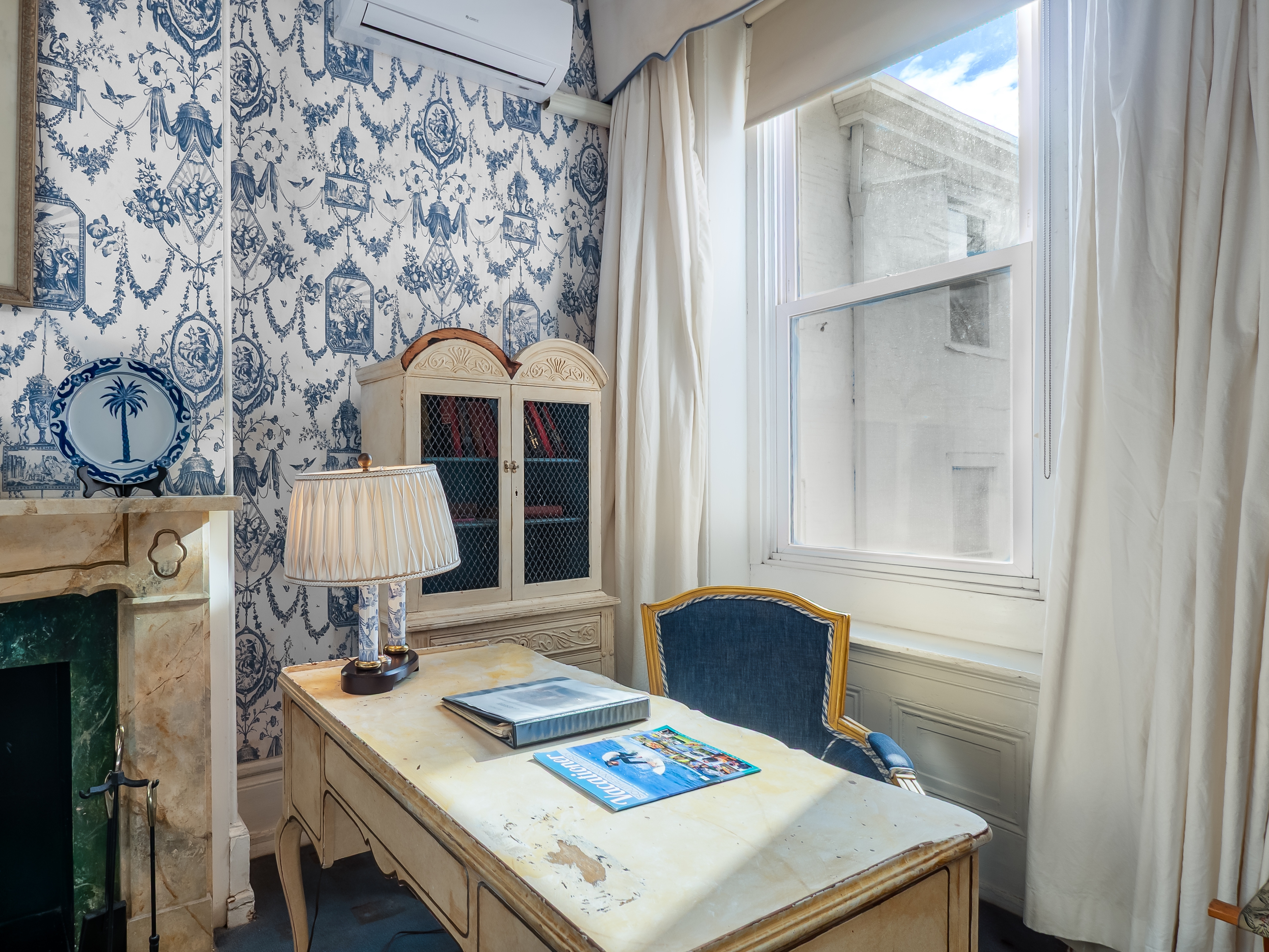 Natural light shines on a desk in front of a window.