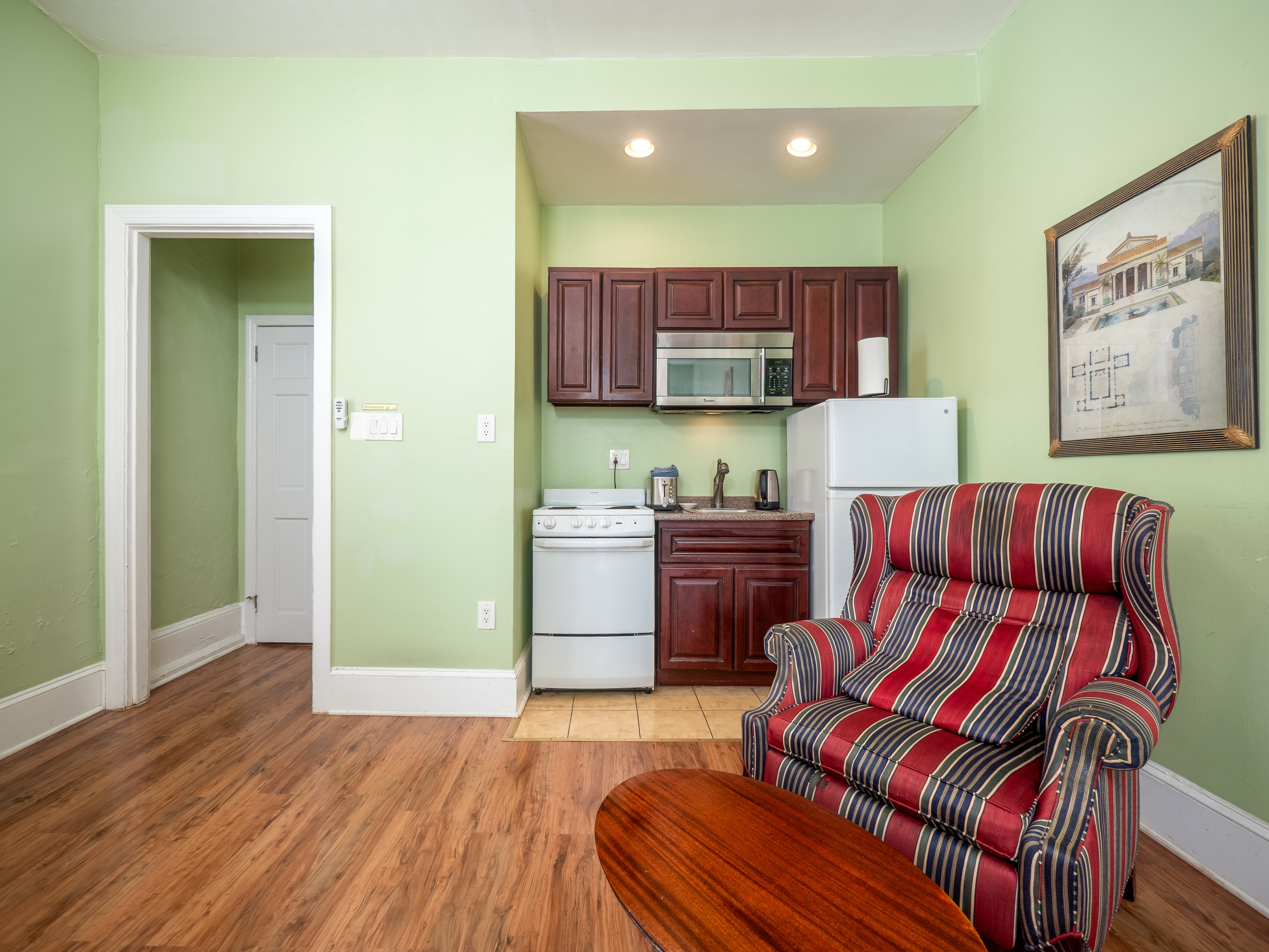 Shot of the kitchenette with the armchair and side table in front view.