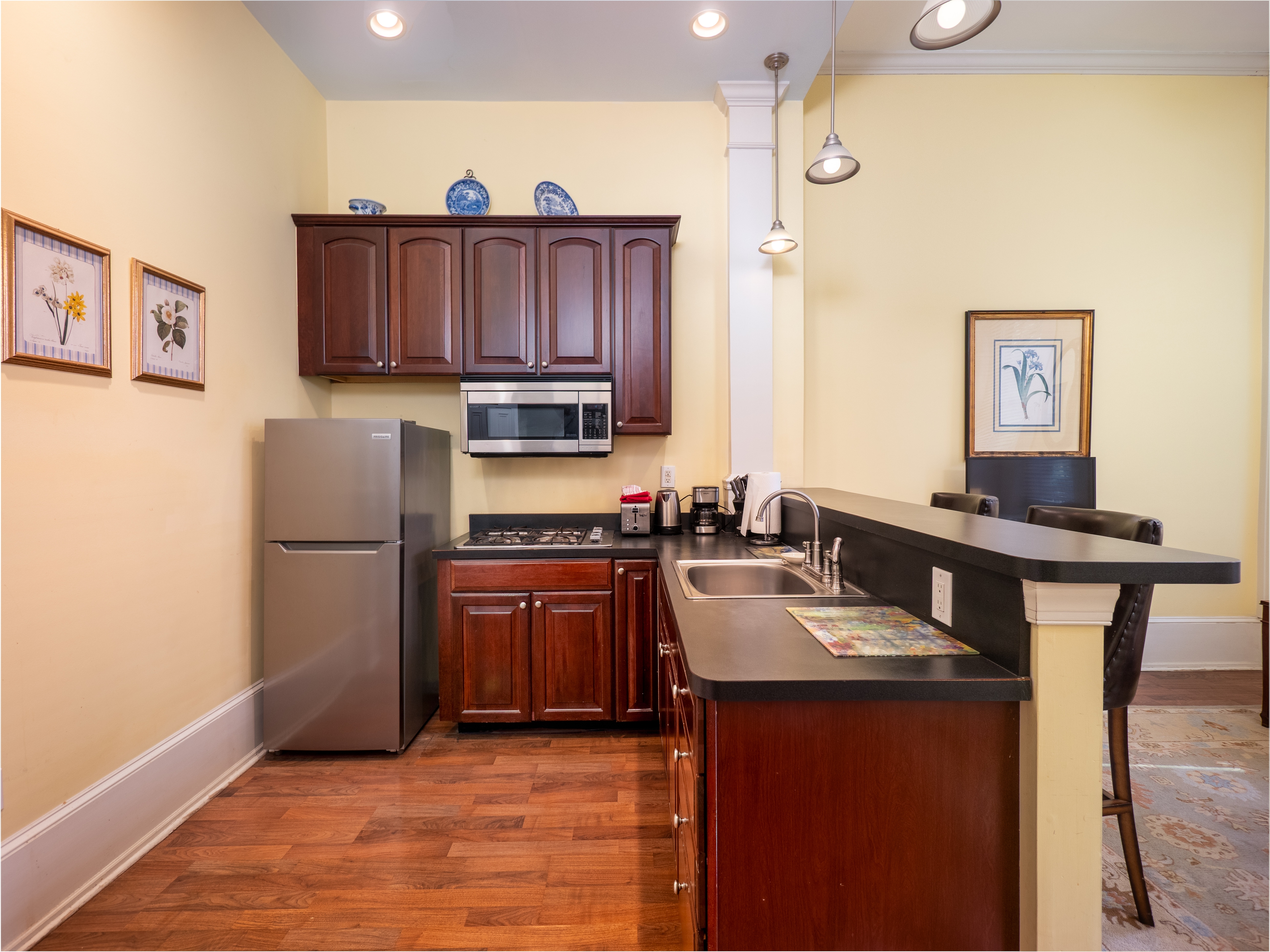 Close up of the full kitchen with bar stool seating at the counters.