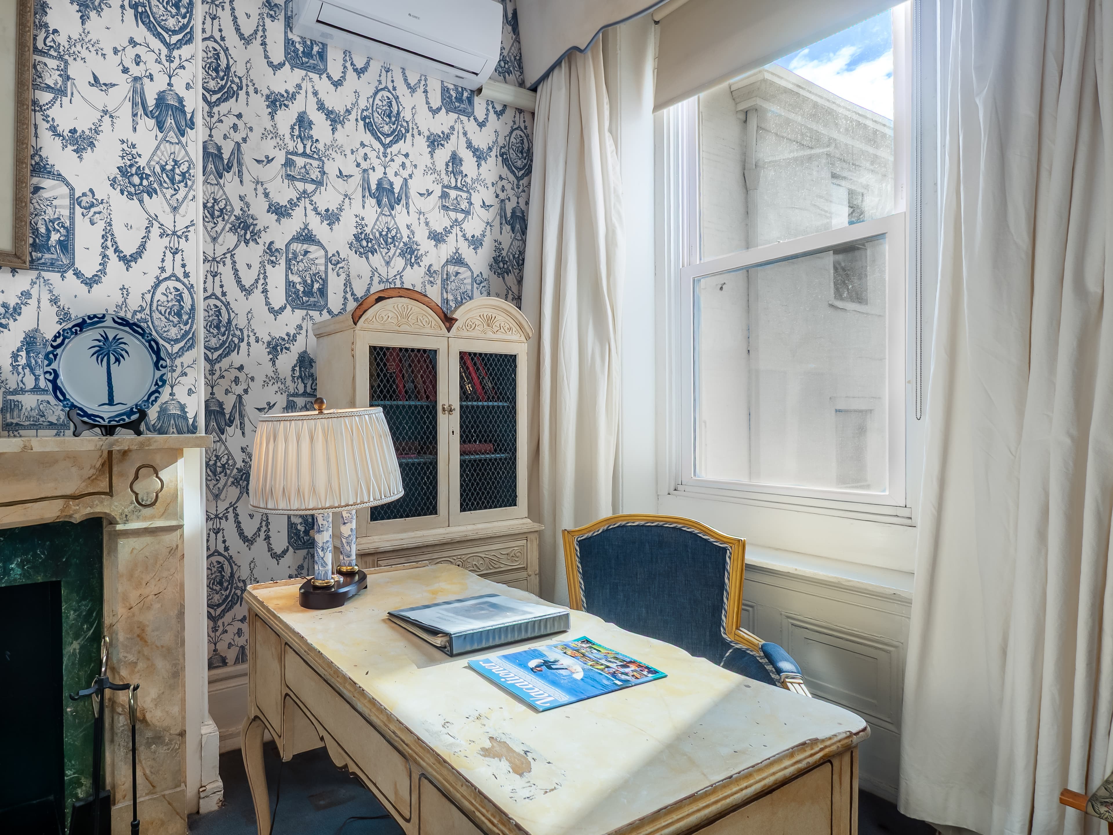 Natural light shines on a desk in front of a window.