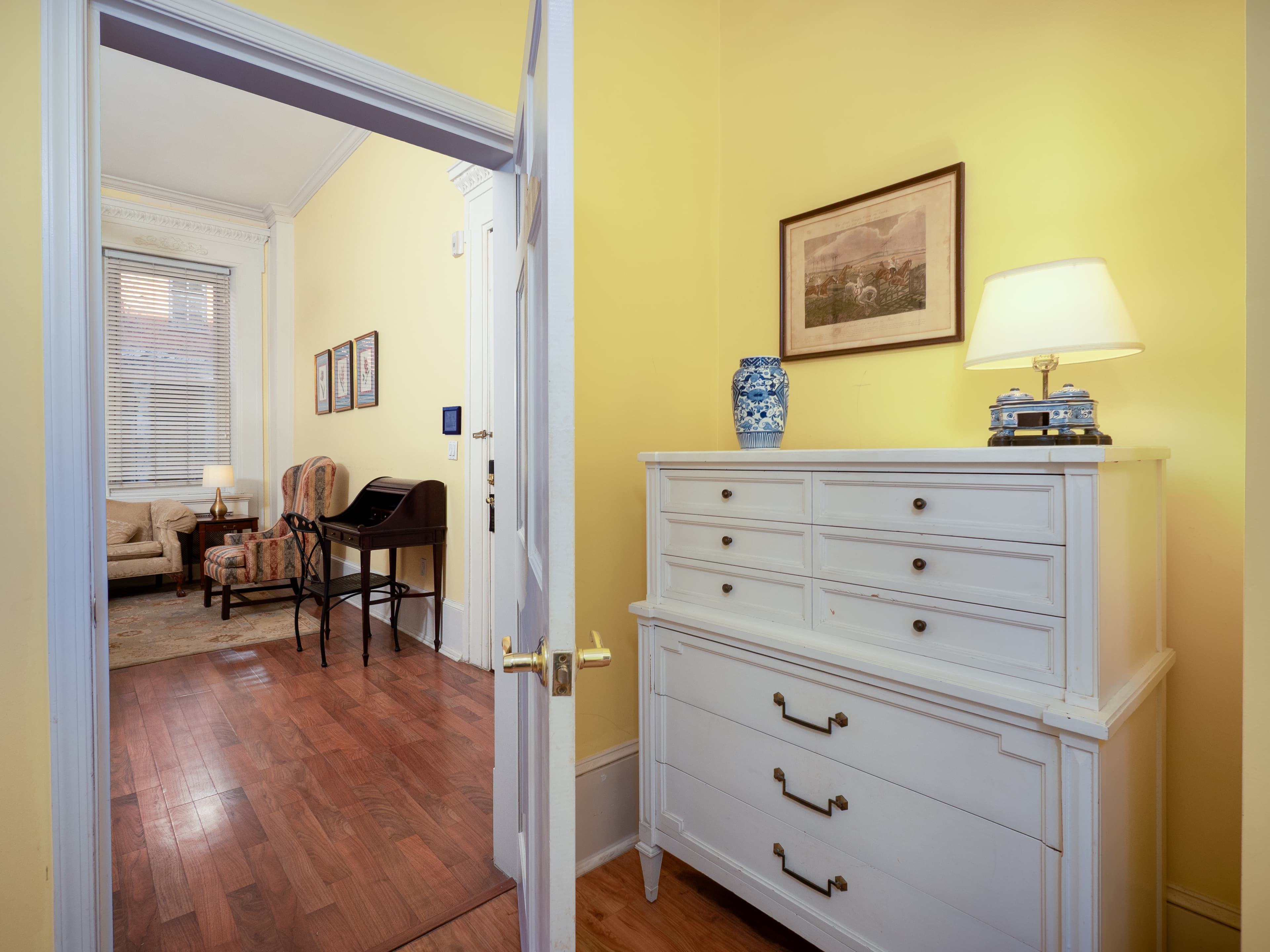 Open shot of the dresser in the bedroom and a view of the unit through the open door.