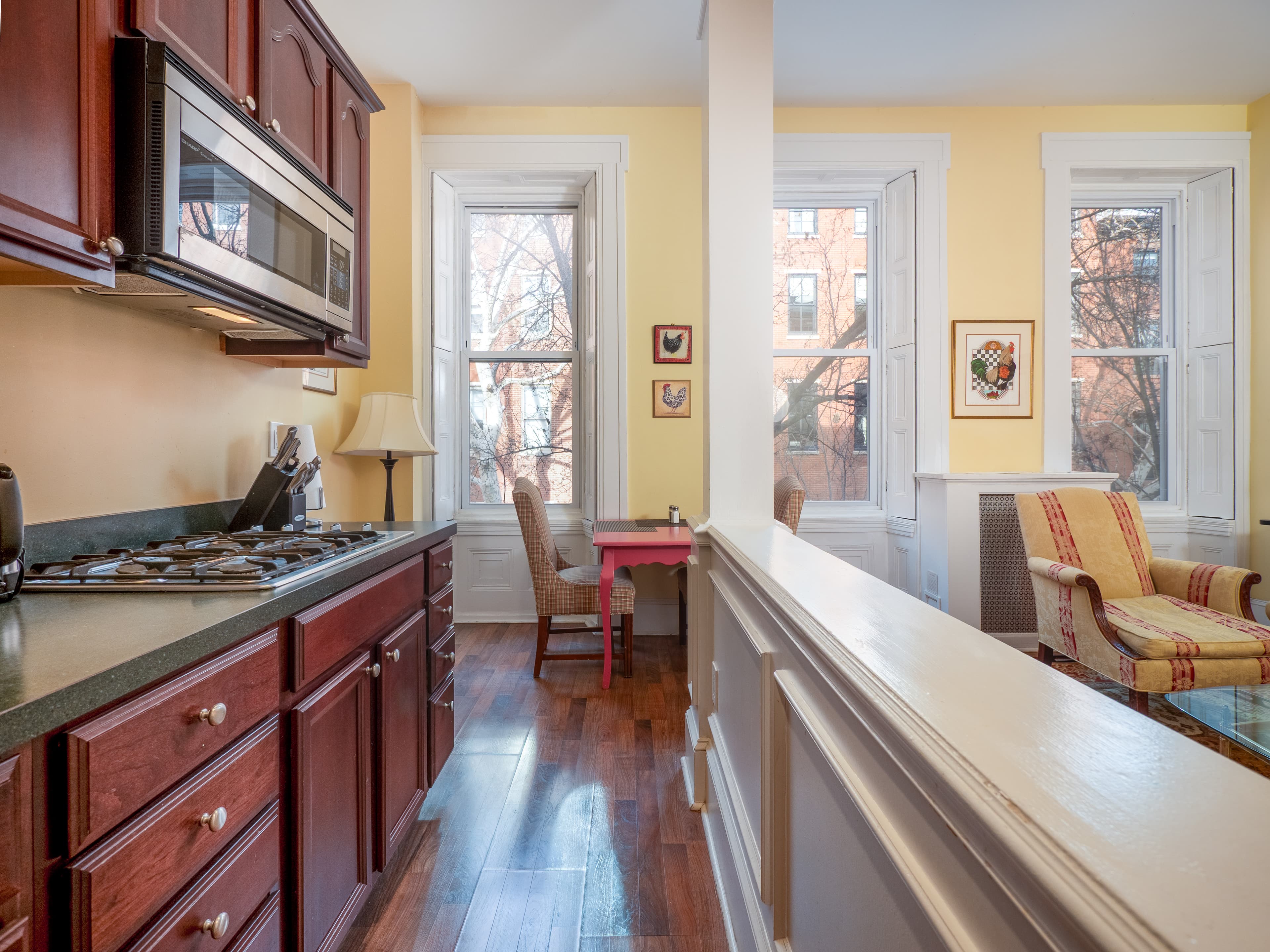 View from the end of the kitchen facing the living room area and windows.