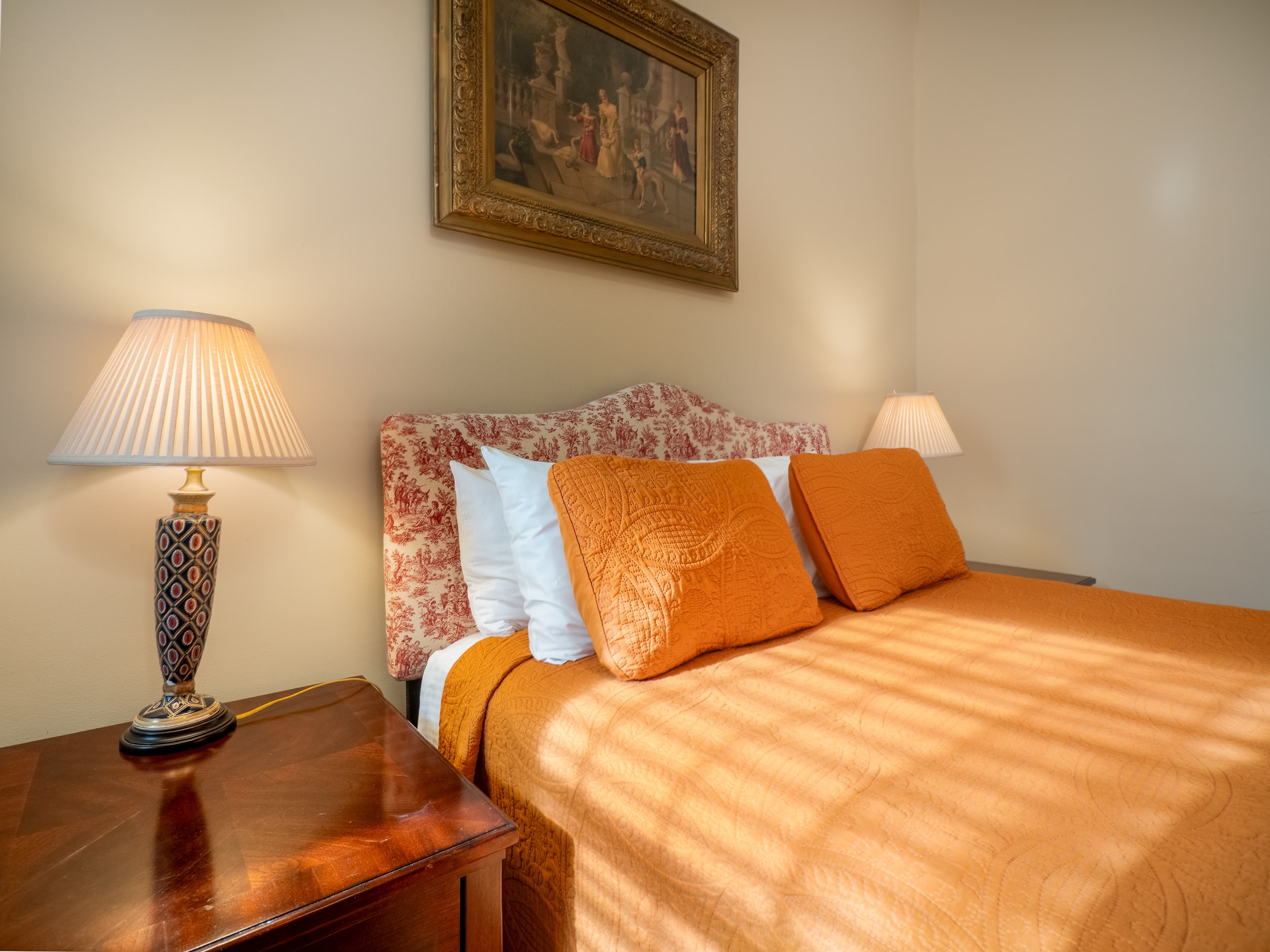 Lovely close up of the queen bed and side tables with lamps on the game.