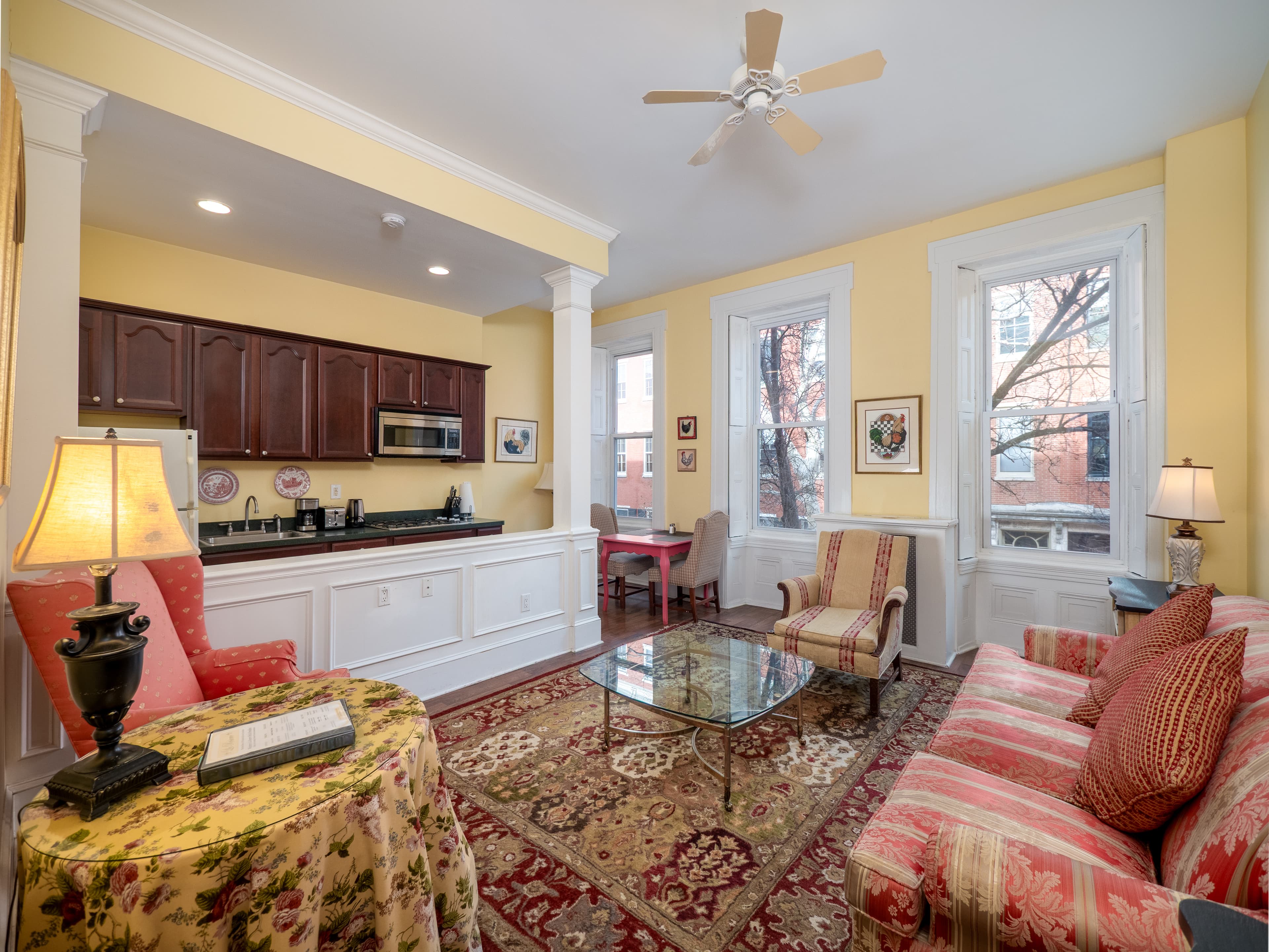 Living room with full kitchen and windows providing natural light.